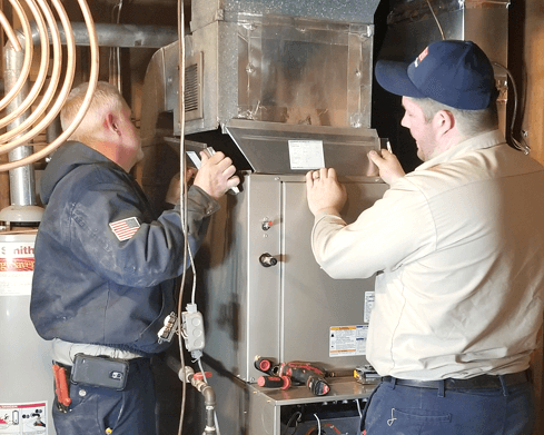 Techs working on a furnace repair
